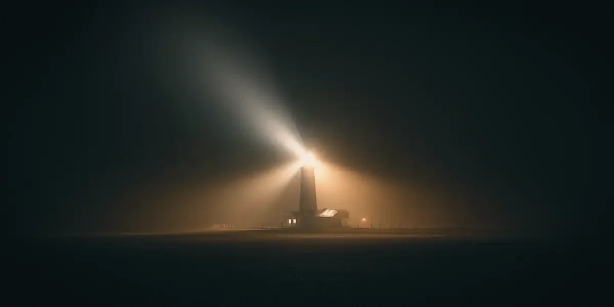 A lighthouse burning through Gulf fog